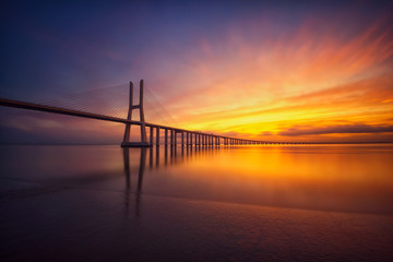 Colorido amanecer con el puente Vasco da Gama al fondo, Lisboa, Portugal.