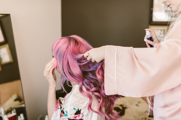 putting on makeup with pink and purple hair