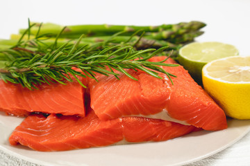 Salmon Fillet with Rosemary, Asparagus, and Lemon, Close Up on a Plate, on White Background. Omega-3, Healthy Food Concept