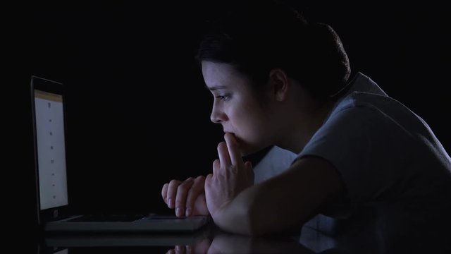 Nervous girl reloading webpage on laptop awaiting result of university entering