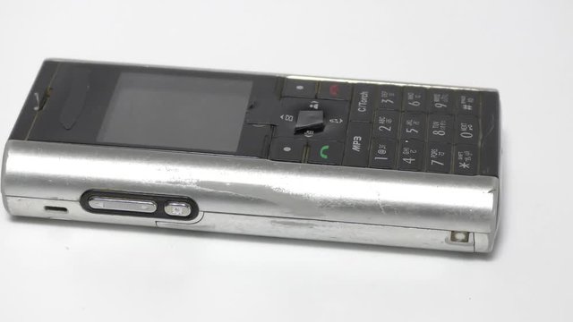 Old used mobile phone on display and moving