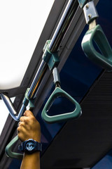 A man clings to handrails in public transport.