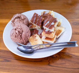 Chocolate ice cream with Milk toast.In a white plate on a wooden table