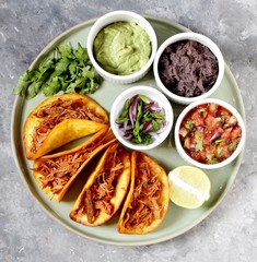 tacos with pork long languor and different sauces, salsa, guacamole, ketchup, cilantro. fried tortilla cakes