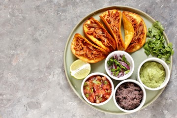 tacos with pork long languor and different sauces, salsa, guacamole, ketchup, cilantro. fried tortilla cakes