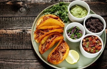 tacos with pork long languor and different sauces, salsa, guacamole, ketchup, cilantro. fried tortilla cakes