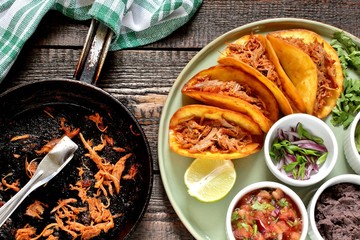 tacos with pork long languor and different sauces, salsa, guacamole, ketchup, cilantro. fried tortilla cakes