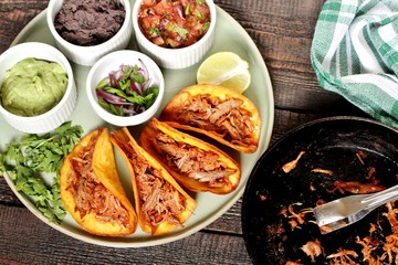 tacos with pork long languor and different sauces, salsa, guacamole, ketchup, cilantro. fried tortilla cakes
