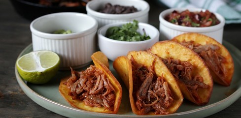 tacos with pork long languor and different sauces, salsa, guacamole, ketchup, cilantro. fried tortilla cakes