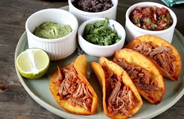 tacos with pork long languor and different sauces, salsa, guacamole, ketchup, cilantro. fried tortilla cakes