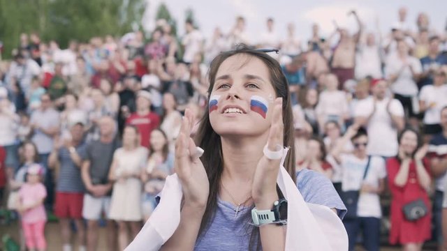 Crazy emotional russian football fan celebrate goal. Young woman get wild supporting favourite team