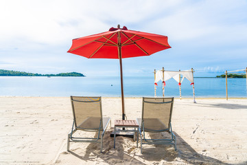 Beautiful outdoor tropical beach sea ocean with umbrella chair and lounge deck around there on white cloud blue sky