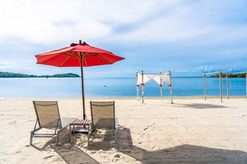 Beautiful outdoor tropical beach sea ocean with umbrella chair and lounge deck around there on white cloud blue sky
