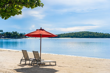 Beautiful outdoor tropical beach sea ocean with umbrella chair and lounge deck around there on white cloud blue sky