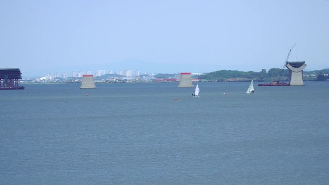 Wide angle Sailing at Asanho lake at Pyeongtaekho torist site, view on Wollangsan Mountain and bridge construction work