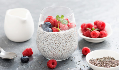 Healthy vanilla chia pudding in a glass with fresh raspberries .