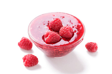 Raspberry jam with fresh berries isolated on white background.