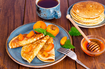 Wheat pancakes with honey and apricots. Photo