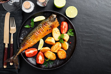 Grilled mackerel fish with roasted potatoes and vegetables.