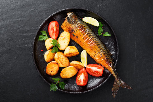 Grilled mackerel fish with roasted potatoes and vegetables.