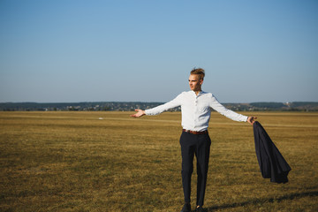 A guy in a suit walks on the field.