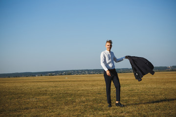 A guy in a suit walks on the field.