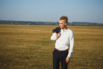 A guy in a suit walks on the field.