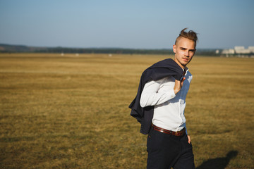 A guy in a suit walks on the field.
