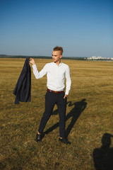 A guy in a suit walks on the field.