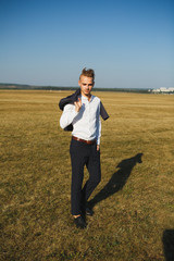 A guy in a suit walks on the field.