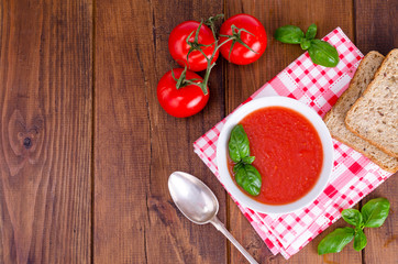 Cold tomato soup on wooden surface. Photo