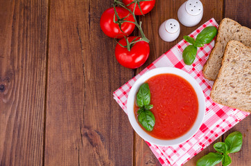 Cold tomato soup on wooden surface. Photo