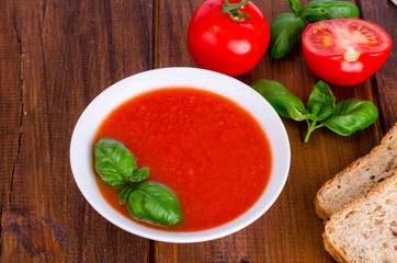 Cold tomato soup on wooden surface. Photo