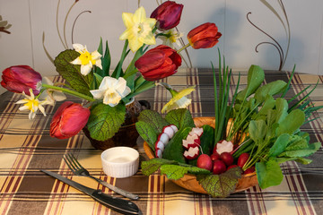bouquet of tulips in a vase and vegetables on a wooden table
