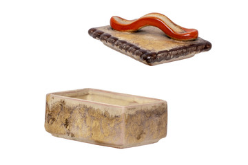 Cigarette box isolated. Closeup of antique brown cigarette case with a red handle made of ceramic isolated on a white background. Macro.