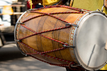 Dhol drummer playing this traditional indian instrument in the street