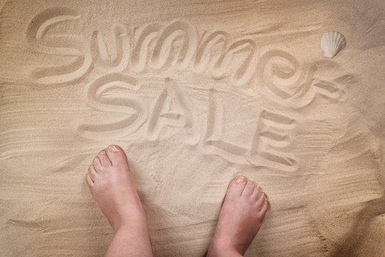 Summer sale inscription on sandy beach, personal point of view.