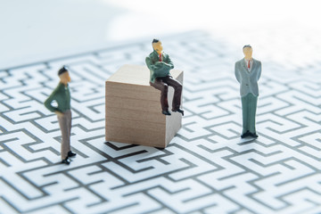 Miniature people: Businessman standing on start point of maze