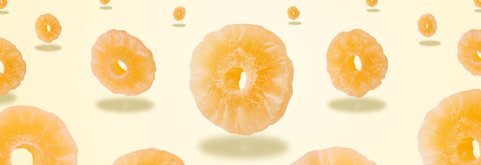 dried pineapple fruit levitating over yellow background, panoramic image, creative minimalism