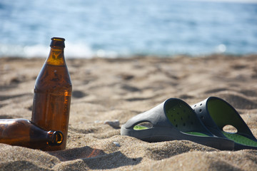 Obraz premium Cold beer and slippers on sand at beach. Summer vacation concept, enjoy at beach
