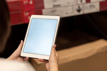 worker hand holding pad for check order pick time in smart factory warehouse