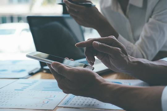 Asian advertising designer creative start-up team discussing ideas in office.