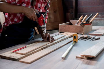 Carpenter working with equipment on wooden table in carpentry shop. woman works in a carpentry shop.