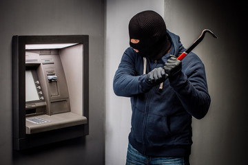 Fototapeta na wymiar thief with crowbar opens the ATM.