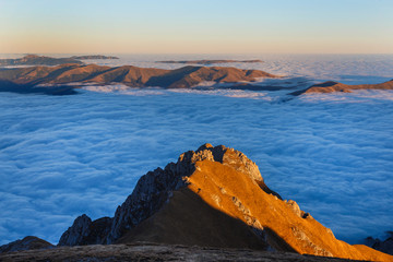 Sunset in the autumn alpine mountains, above the clouds, sea of clouds, Carpathians