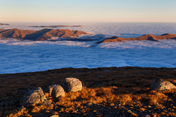 Fototapeta na wymiar Sunset in the autumn alpine mountains, above the clouds, sea of clouds, Carpathians