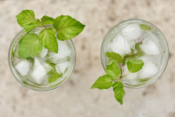 Summer hot fresh drink with mint in glass on white green grey background