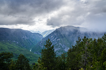 Fototapeta na wymiar Montenegro, Spectacular view over tara river canyon with dramatic sky of rain clouds and sun from mountain curevac in durmitor national park nature landscape of zabljak