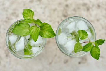 Summer hot fresh drink with mint in glass on white green grey background