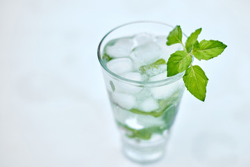 Summer hot fresh drink with mint in glass on white green grey background